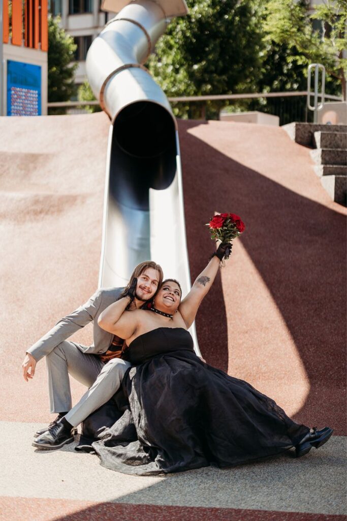 Happy newlyweds posing on a slide