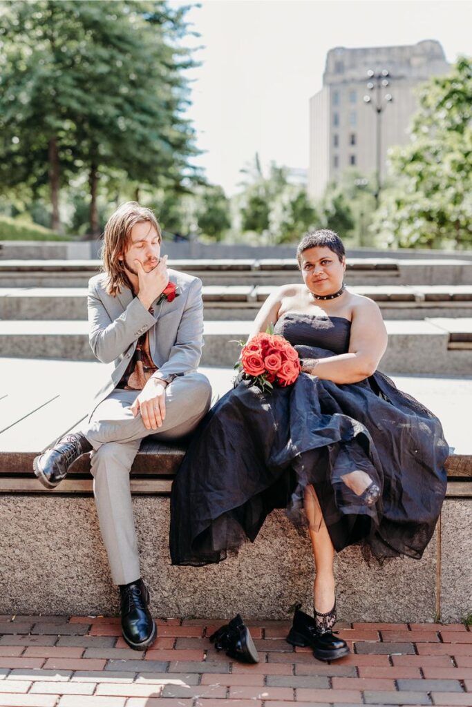 Tara and Clint sitting on a bench after their Boston city hall elopement 