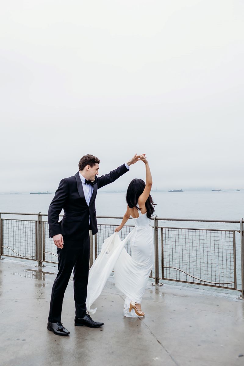 man in a suit spinning a woman in a wedding dress 