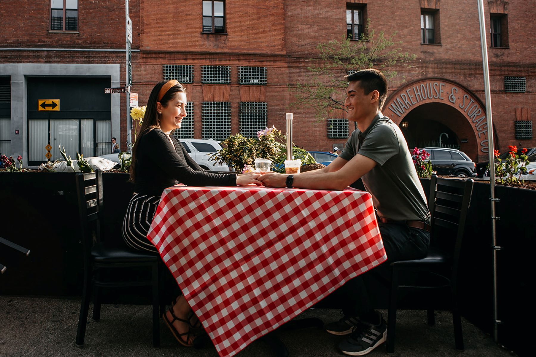 man and woman sitting at a restaurant holding hands across the table 