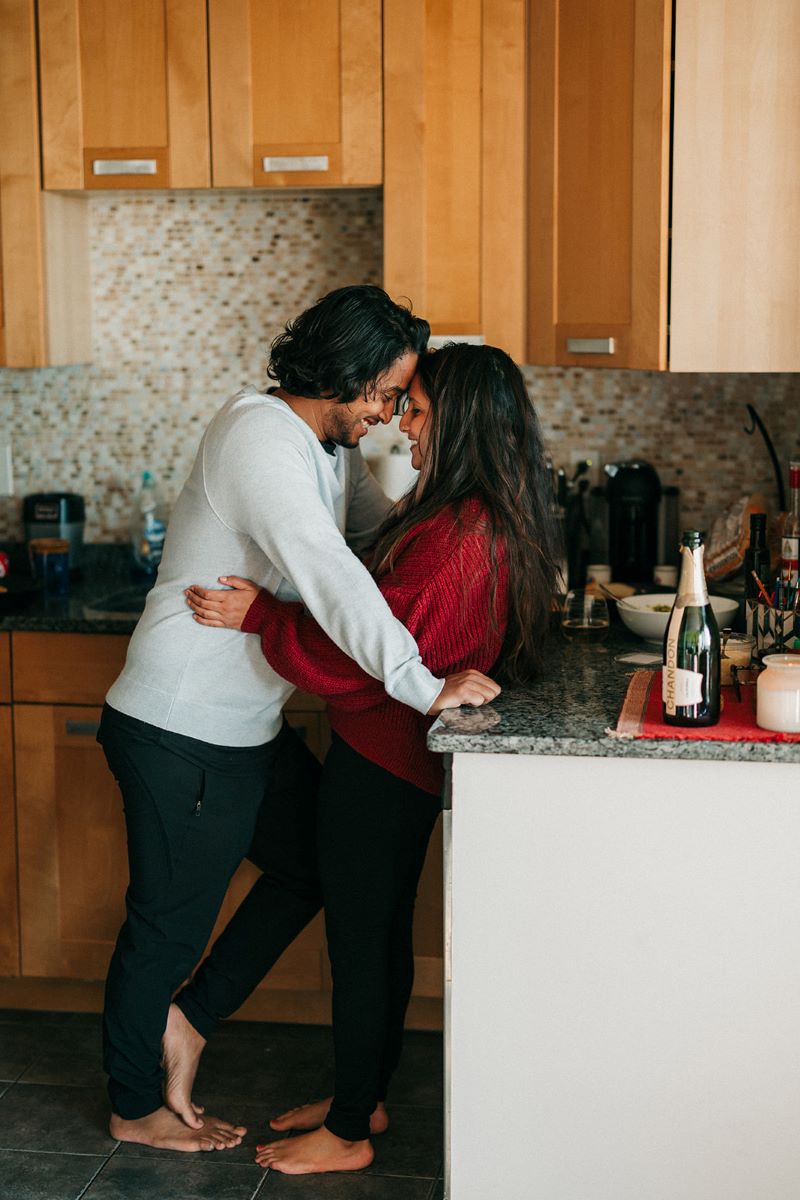 man and woman in the kitchen touching foreheads 