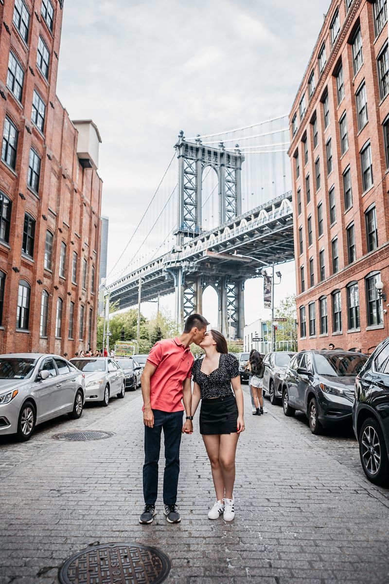 man giving woman a kiss on a brick street 