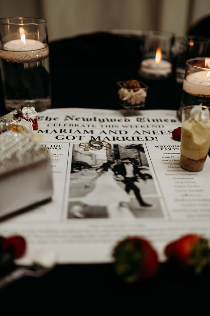 A custom newspaper announcing a wedding with wedding rings, flowers, and desserts on top 