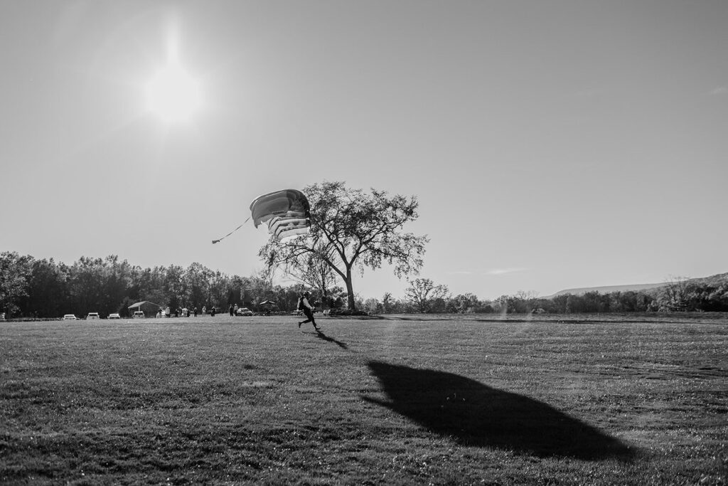 A groom parachuting into his wedding in a field  