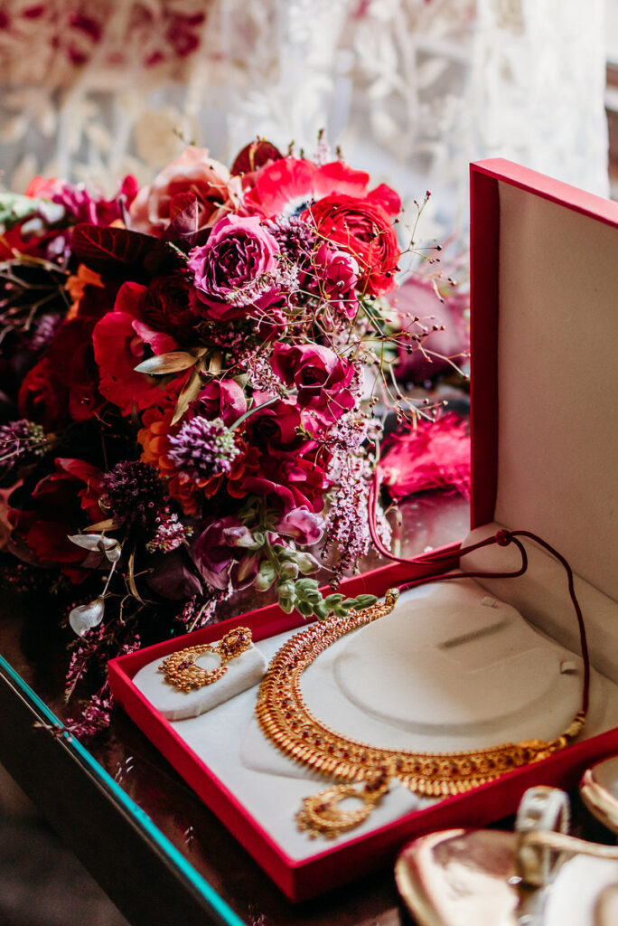 Bold flowers next to a box with a necklace and earrings in it. 