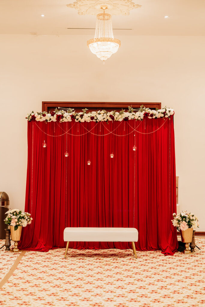 A red drape with flowers along the top 