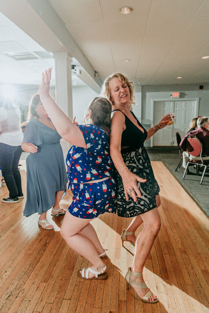 A bride dancing with a wedding guests at her reception 