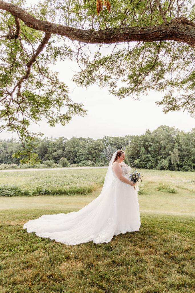 A person in a wedding dress holding a bouquet of flowers in a field 
