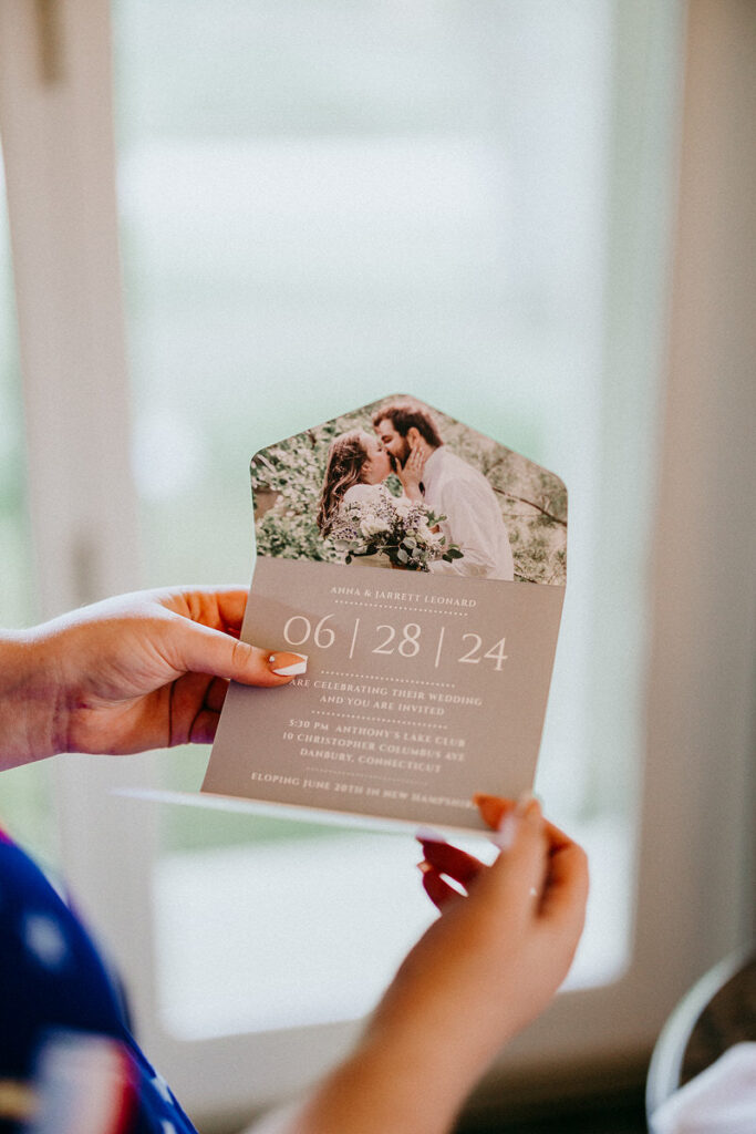 Hands holding up a wedding invitation 