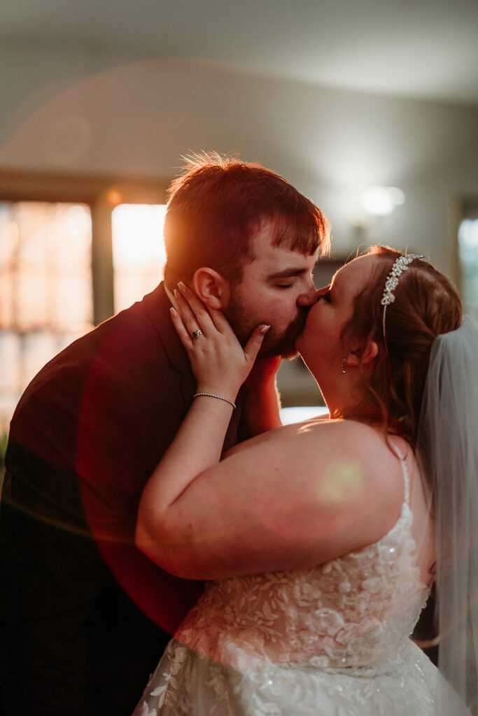 A person kissing their partner on their wedding day 