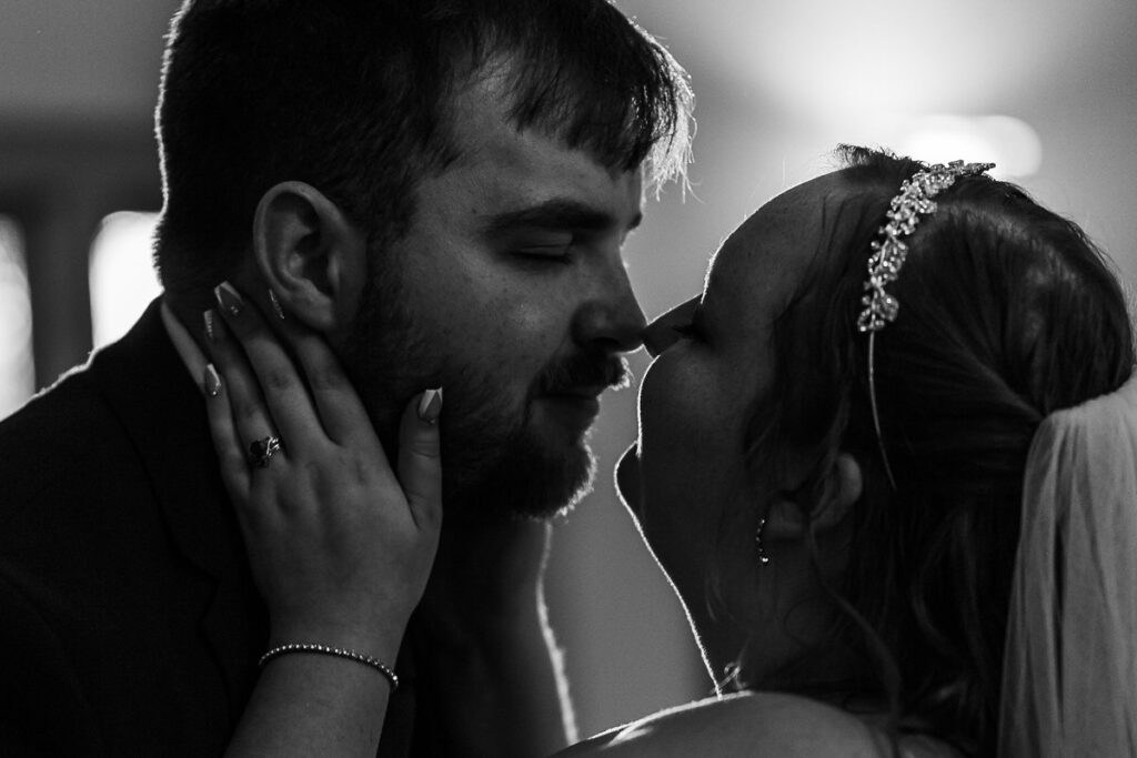 A person with their hands on their partner's face as they lean in for a kiss 
