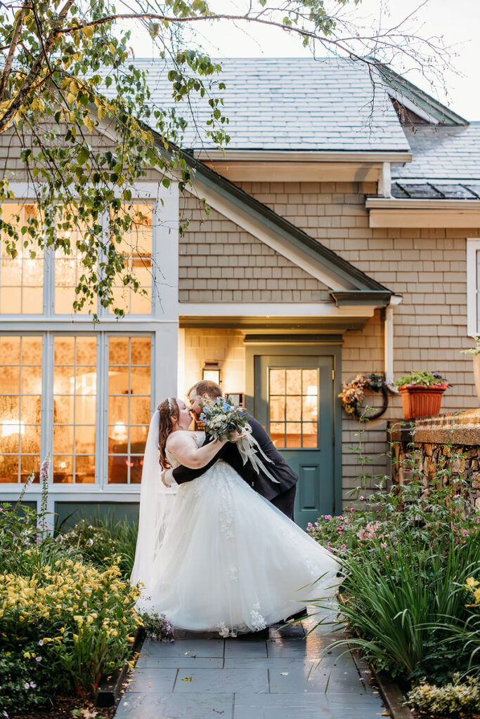 A person dipping their partner and kissing them on their wedding day 