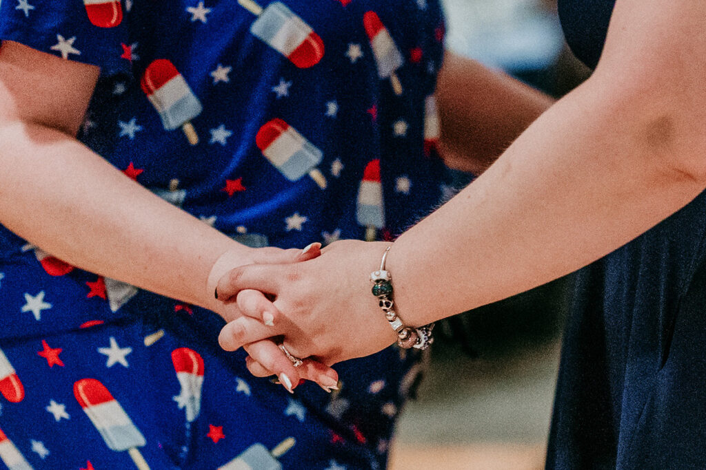 A close up view of two people holding hands 