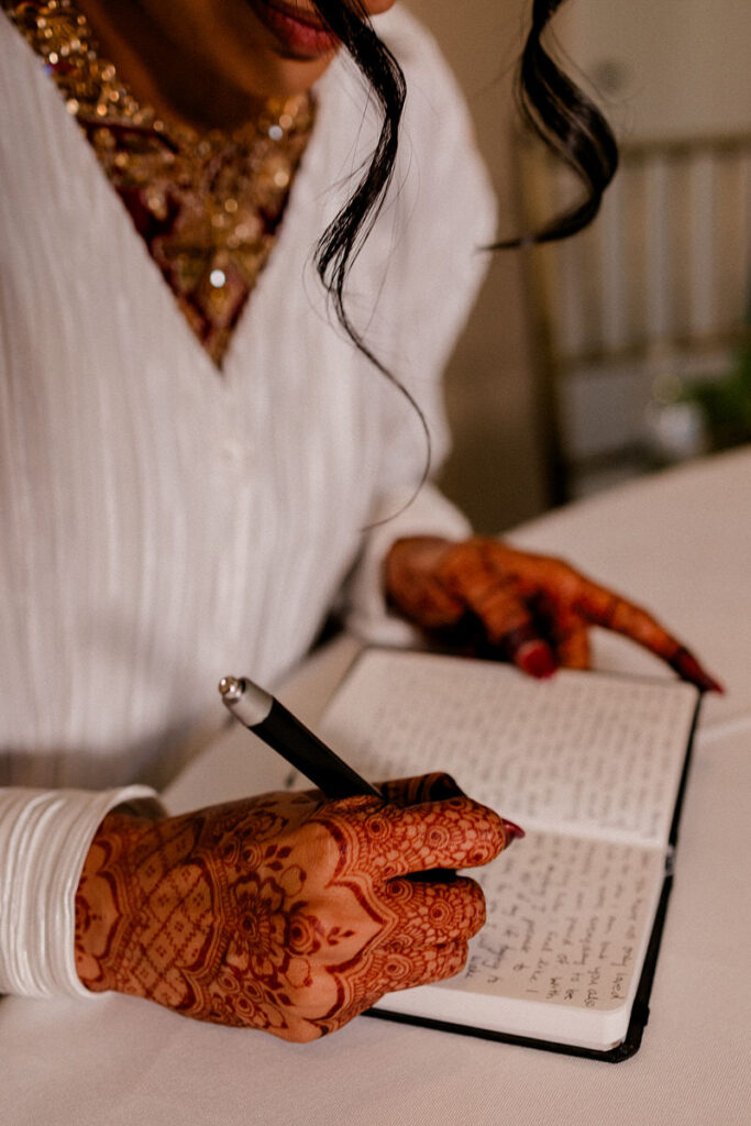 A bride writing in a small notebook 
