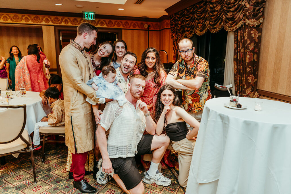 Guests kneeling and laughing in front of a round table 