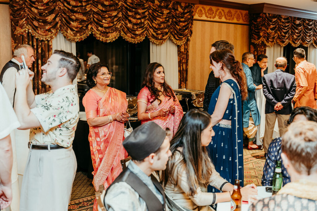 Wedding guests chatting in a reception hall 
