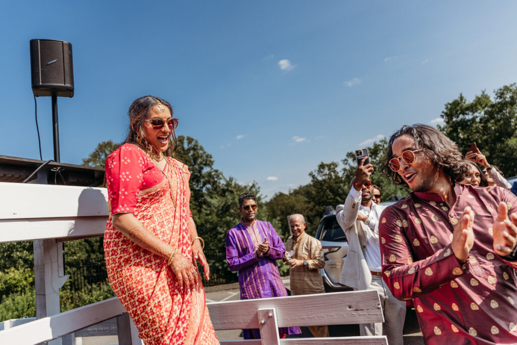 A wedding couple standing on a small platform together smiling 