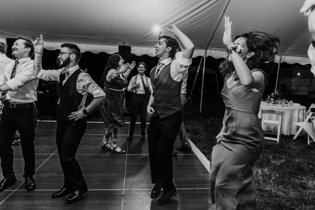 Wedding guests dancing at an outdoor reception 