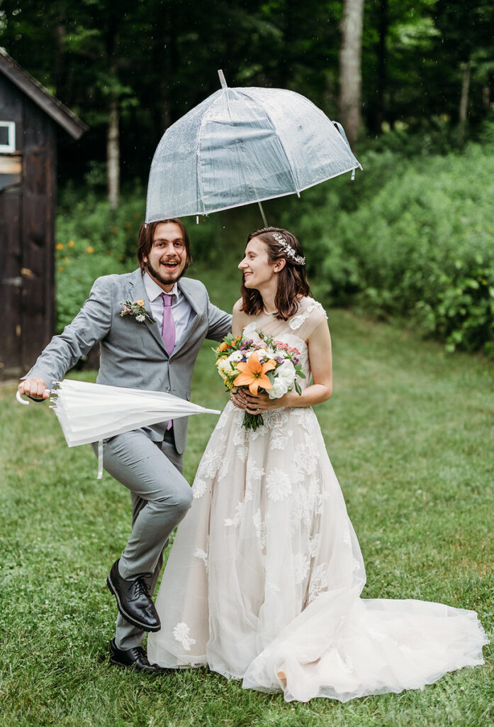 A person skipping next to their partner as one holds an umbrella up during their wedding day