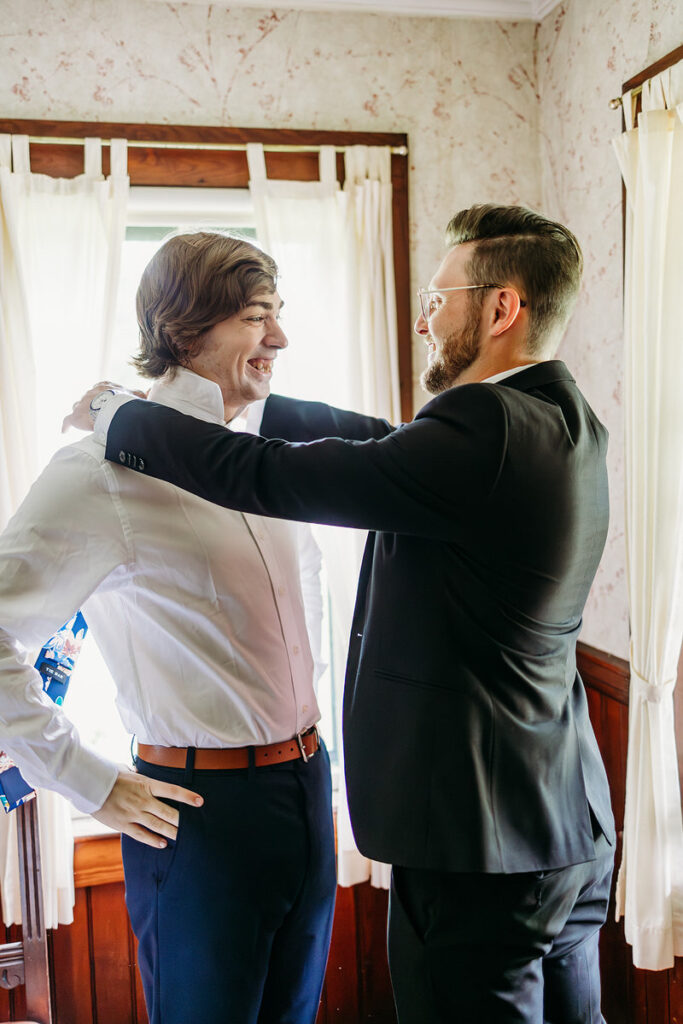 A person helping a soon-to-be-wed put on their tie 