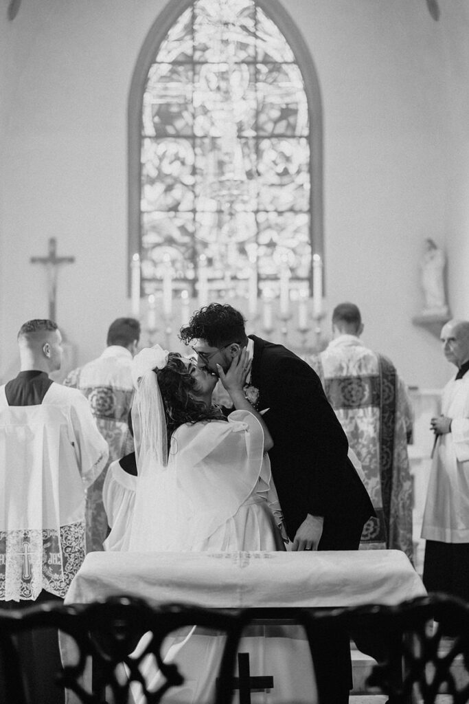 A couple during their first kiss at their wedding 